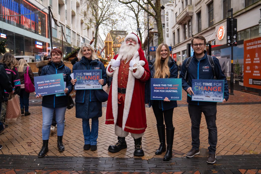 campaigners with placards stand with Santa in the middle